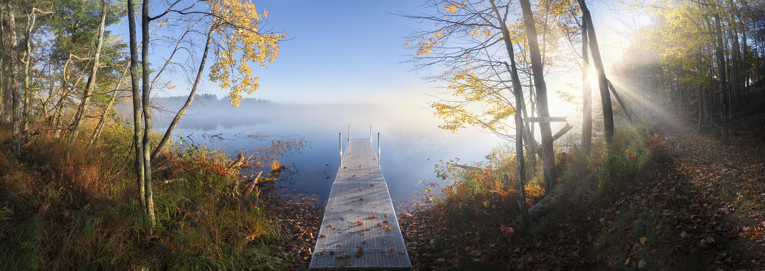 Foggy fall dock with leaves at sunrise