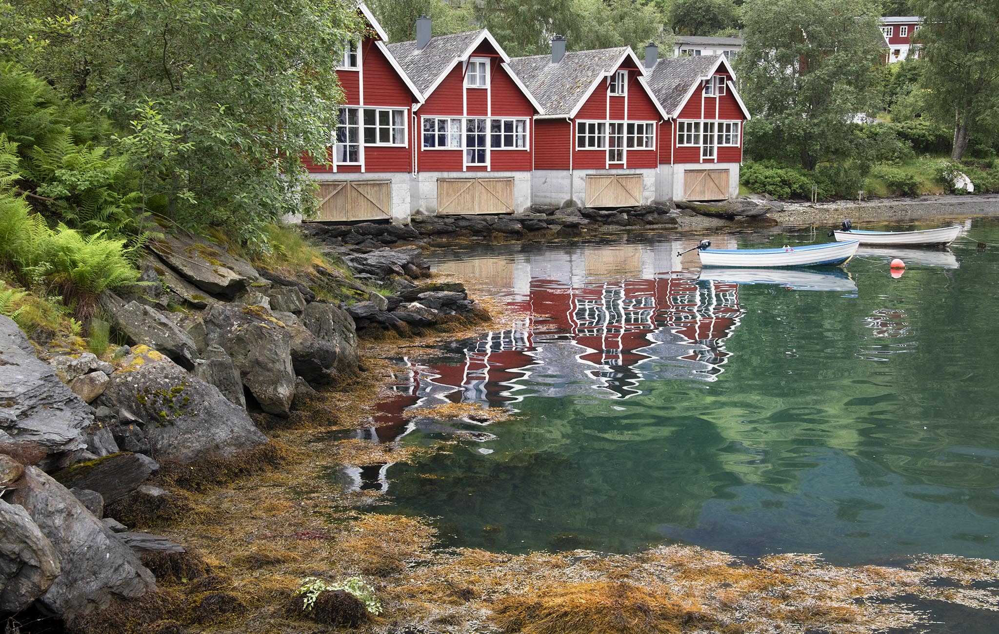 Four red cabins on waterfront in Flam